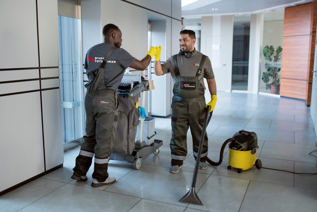 La imagen muestra dos trabajadores de Totseriman dándose el puño, representando el trabajo en equipo.